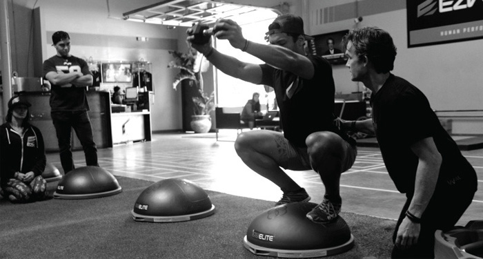 Приседания с гантелью на балансировочной платформе Босу